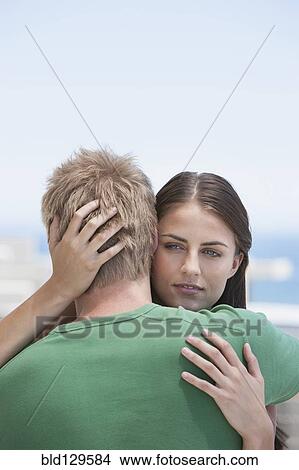 Picture - Caucasian couple hugging outdoors. Fotosearch
