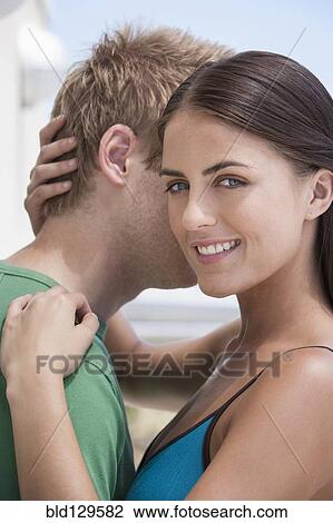 Stock Image - Caucasian couple hugging outdoors. Fotosearch