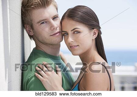 Stock Image - Caucasian couple hugging outdoors. Fotosearch