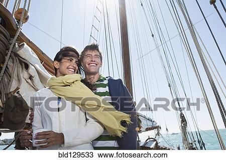 Stock Image - Caucasian couple on sailboat. Fotosearch