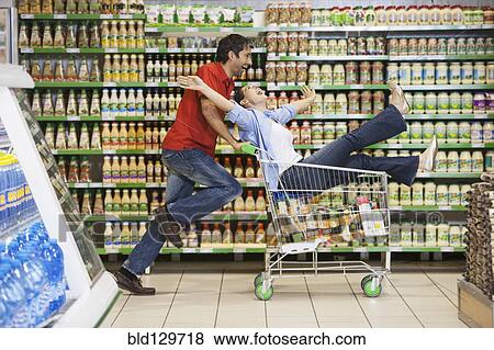Stock Photo - Caucasian couple playing in grocery store. Fotosearch