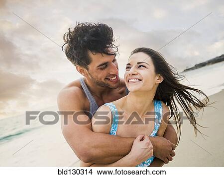 Picture - Caucasian couple playing on beach. Fotosearch