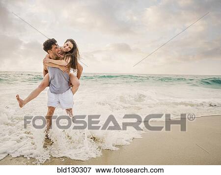 Caucasian couple playing on beach View Large Photo Image Stock Photo - Caucasian couple playing on beach. Fotosearch