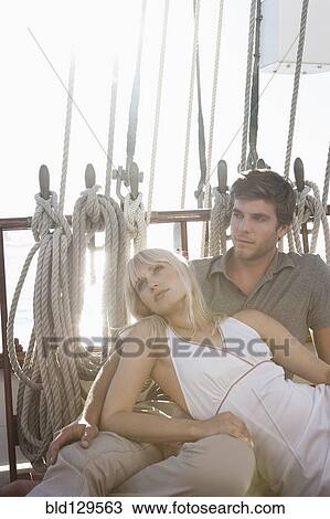 Caucasian couple relaxing on sailboat View Large Photo Image Stock Image - Caucasian couple relaxing on sailboat. Fotosearch