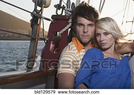Caucasian couple relaxing on sailboat View Large Photo Image Stock Photo - Caucasian couple relaxing on sailboat. Fotosearch