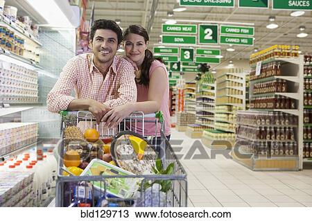 Stock Image - Caucasian couple shopping in grocery store. Fotosearch