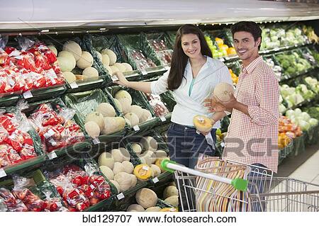 Stock Photo - Caucasian couple shopping in grocery store. Fotosearch