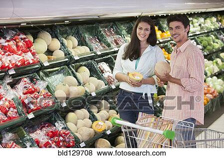 Caucasian couple shopping in grocery store View Large Photo Image Stock Photo - Caucasian couple shopping in grocery store. Fotosearch