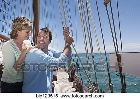 Stock Photography - Caucasian couple smiling on sailboat. Fotosearch