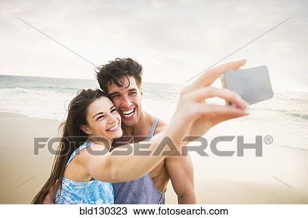 Caucasian couple taking pictures on beach View Large Photo Image Stock Image - Caucasian couple taking pictures on beach. Fotosearch