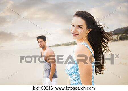 Stock Photograph - Caucasian couple walking on beach. Fotosearch