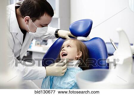 Caucasian dentist examining girl's teeth View Large Photo Image Stock Photo - Caucasian dentist examining girl's teeth. Fotosearch