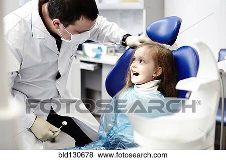 Caucasian dentist examining girl's teeth View Large Photo Image Stock Photo - Caucasian dentist examining girl's teeth. Fotosearch