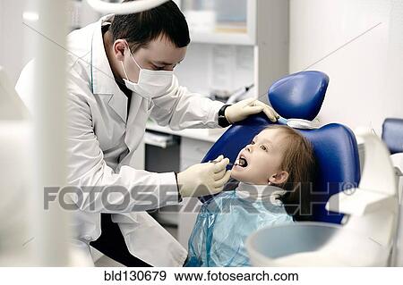 Caucasian dentist examining girl's teeth View Large Photo Image Stock Photo - Caucasian dentist examining girl's teeth. Fotosearch