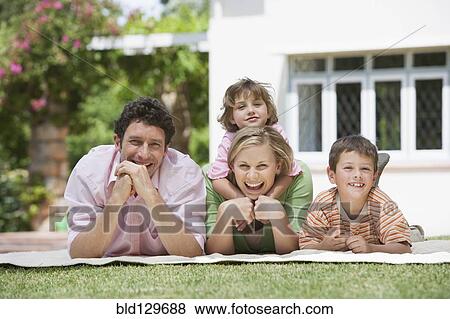 Stock Photo - Caucasian family relaxing in backyard. Fotosearch