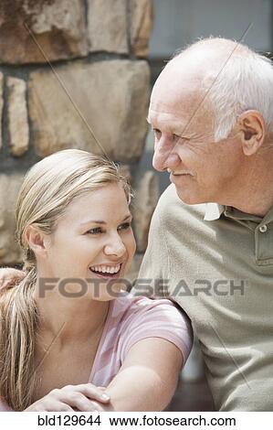 Picture - Caucasian father and daughter relaxing outdoors. Fotosearch