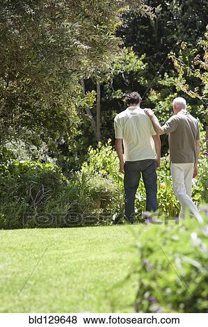 Caucasian father and son walking in park View Large Photo Image Stock Photo - Caucasian father and son walking in park. Fotosearch