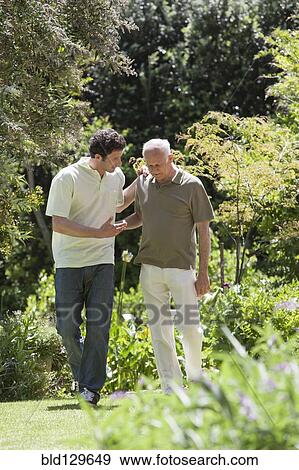 Caucasian father and son walking in park View Large Photo Image Stock Photo - Caucasian father and son walking in park. Fotosearch