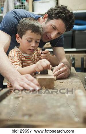 Caucasian father and son working in woodshop View Large Photo Image Stock Photo - Caucasian father and son working in woodshop. Fotosearch