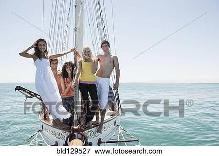 Stock Photo - Caucasian friends on sailboat. Fotosearch