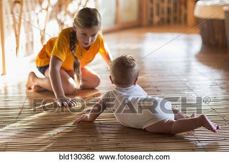 Caucasian girl and baby sibling playing on floor View Large Photo Image Stock Image - Caucasian girl and baby sibling playing on floor. Fotosearch
