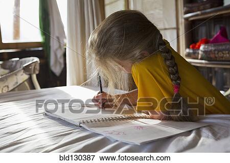 Caucasian girl drawing in notebook on bed View Large Photo Image Stock Photo - Caucasian girl drawing in notebook on bed. Fotosearch