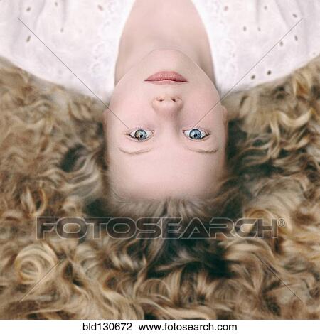 Stock Image - Caucasian girl laying on ground. Fotosearch
