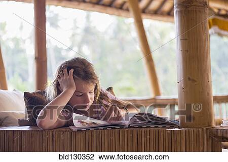 Caucasian girl reading book on patio View Large Photo Image Stock Image - Caucasian girl reading book on patio. Fotosearch