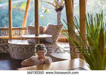 Stock Image - Caucasian girl relaxing on patio. Fotosearch