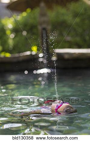 Caucasian girl spraying water in swimming pool View Large Photo Image Stock Photo - Caucasian girl spraying water in swimming pool. Fotosearch