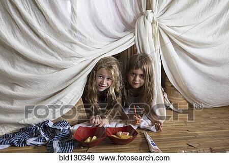 Caucasian girls playing in blanket fort View Large Photo Image Stock Photo - Caucasian girls playing in blanket fort. Fotosearch