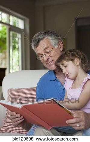 Caucasian man reading to granddaughter View Large Photo Image Stock Photo - Caucasian man reading to granddaughter. Fotosearch
