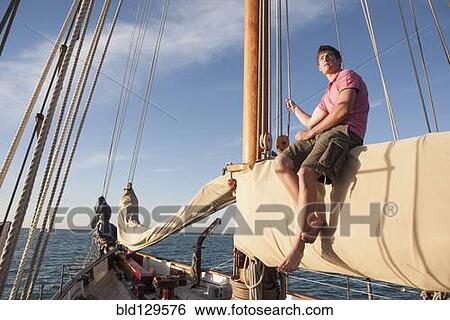 Caucasian man relaxing on sailboat View Large Photo Image Stock Photograph - Caucasian man relaxing on sailboat. Fotosearch