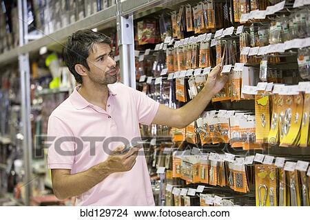 Picture - Caucasian man shopping in hardware store. Fotosearch
