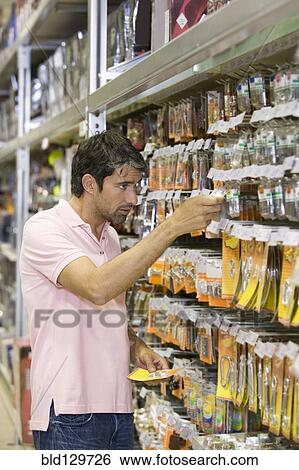 Caucasian man shopping in hardware store View Large Photo Image Stock Photograph - Caucasian man shopping in hardware store. Fotosearch