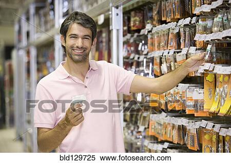 Stock Photography - Caucasian man shopping in hardware store. Fotosearch