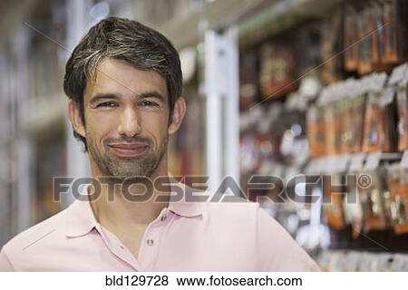 Caucasian man smiling in hardware store View Large Photo Image Stock Photo - Caucasian man smiling in hardware store. Fotosearch