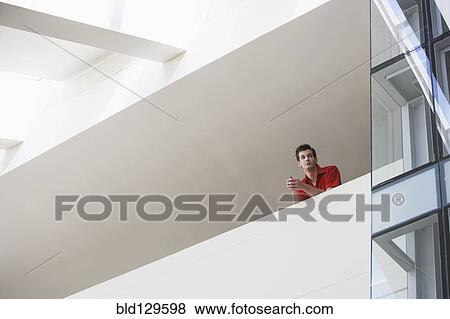 Caucasian man standing on atrium balcony View Large Photo Image Stock Photo - Caucasian man standing on atrium balcony. Fotosearch