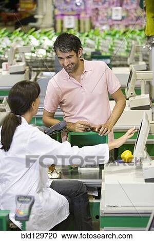 Caucasian man talking to cashier in grocery store View Large Photo Image Stock Image - Caucasian man talking to cashier in grocery store. Fotosearch