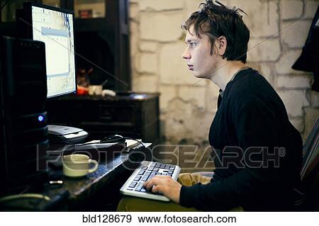 Caucasian man using computer at desk View Large Photo Image Stock Photo - Caucasian man using computer at desk. Fotosearch
