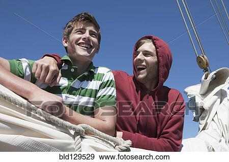 Stock Photo - Caucasian men on sailboat. Fotosearch