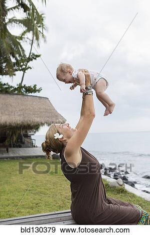Stock Photo - Caucasian mother and baby playing outdoors. Fotosearch