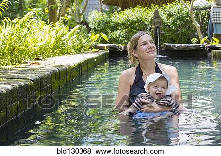 Caucasian mother and baby relaxing in swimming pool View Large Photo Image Stock Photo - Caucasian mother and baby relaxing in swimming pool. Fotosearch