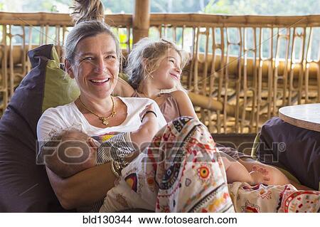 Caucasian mother and children relaxing on patio View Large Photo Image Picture - Caucasian mother and children relaxing on patio. Fotosearch