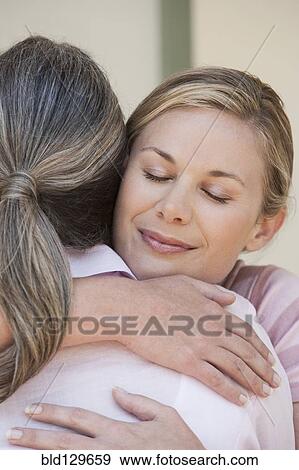Caucasian mother and daughter hugging View Large Photo Image Stock Photo - Caucasian mother and daughter hugging. Fotosearch