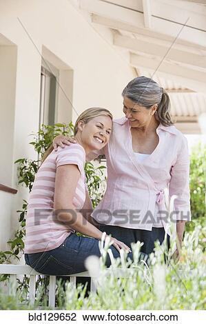 Caucasian mother and daughter relaxing on patio View Large Photo Image Stock Image - Caucasian mother and daughter relaxing on patio. Fotosearch