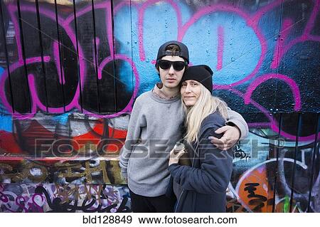 Caucasian mother and son hugging by graffiti wall View Large Photo Image Stock Photo - Caucasian mother and son hugging by graffiti wall. Fotosearch