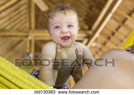 Stock Image - Caucasian mother holding baby in hammock. Fotosearch