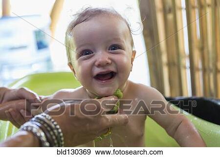 Caucasian mother washing baby in plastic tub View Large Photo Image Stock Photo - Caucasian mother washing baby in plastic tub. Fotosearch