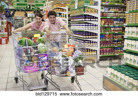 Stock Photography - Caucasian people racing each other at grocery store. Fotosearch